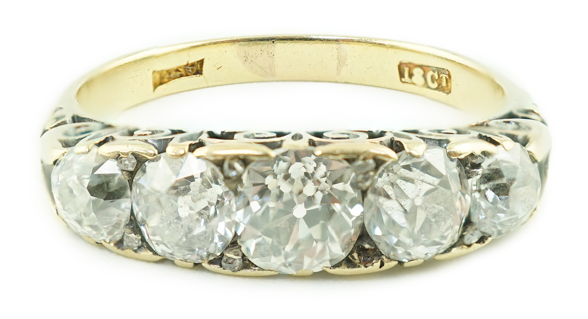 An early 20th century 18ct gold and graduated five stone old cut diamond set half hoop ring